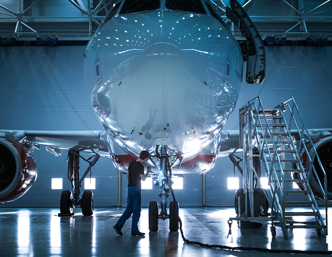 Airplane under maintenance with technician nearby